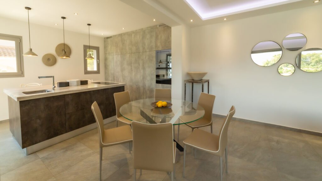 Gallery image depicting dining area with kitchen in the background